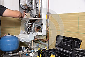 Plumber fixing central heating system, Worker servicing a gas boiler