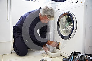 Plumber Fixing Domestic Washing Machine