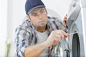 plumber fixing domestic washing machine photo