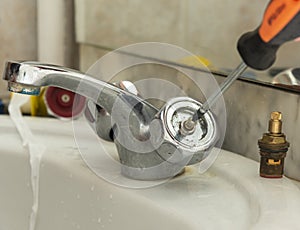 Plumber fixing faucet in bathroom