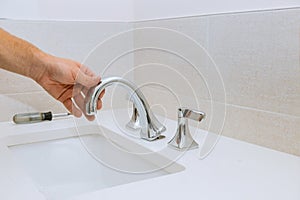 Plumber fixing installation faucet of a sink