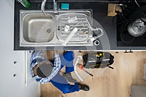 Plumber Fixing Kitchen Pipes