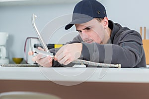 plumber fixing kitchen sink taps