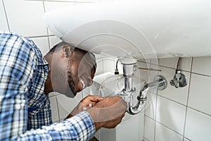 Plumber Fixing Pipe In Bathroom. Plumbing Maintenance