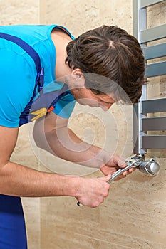 Plumber fixing the radiator