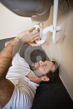 Plumber fixing the sink in a bathroom