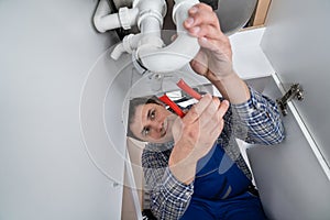 Plumber Fixing Sink In Kitchen