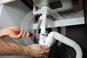 Plumber Fixing Sink Pipe With Adjustable Wrench