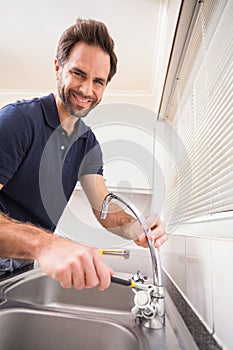 Plumber fixing the sink with wrench