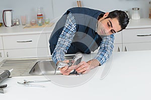 Plumber fixing tap on sink