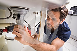 Plumber fixing under the sink