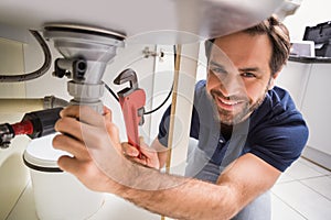 Plumber fixing under the sink