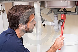 Plumber fixing under the sink