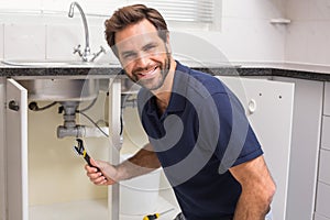 Plumber fixing under the sink