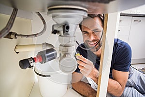 Plumber fixing under the sink