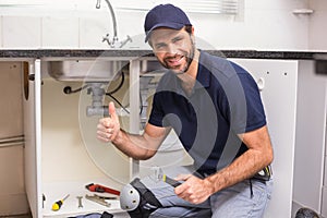 Plumber fixing under the sink