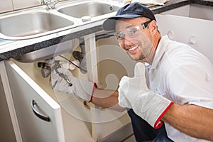 Plumber fixing under the sink