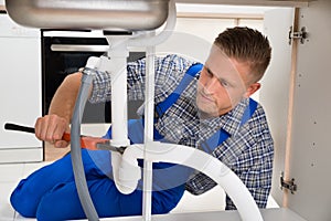 Plumber Fixing White Sink Pipe