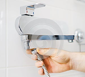 Plumber hands fixing shower mixer