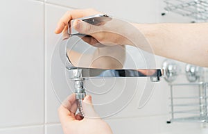 Plumber hands fixing shower mixer