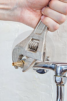 Plumber hands turned water valve faucet using plumbers adjustabl