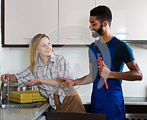 Plumber and housewife in kitchen