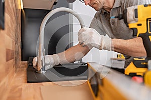 Plumber Installing Kitchen Sink and a Faucet