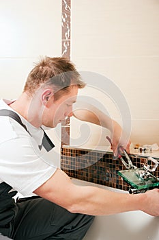 Plumber installing a mixer tap in a bathroom