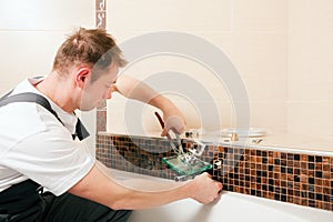 Plumber installing a mixer tap in a bathroom
