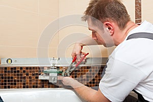 Plumber installing a mixer tap in a bathroom