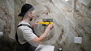 Plumber installing toilet tank in restroom