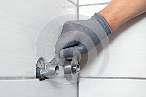 A plumber installs eccentrics to install a faucet in a bathroom
