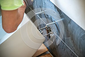 Plumber installs a toilet in a new bathroom. Moving to a new house concept