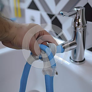 Plumber man fix repair service wraps fluoroplastic sealing material tape around faucet hose. Concept install plumbing in