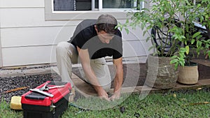 Plumber Man fixing Sprinkler Head in backyard
