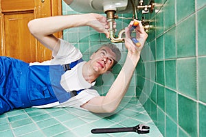 Plumber man repair leaky faucet tap