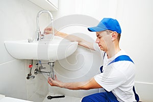 Plumber man repair leaky faucet tap photo