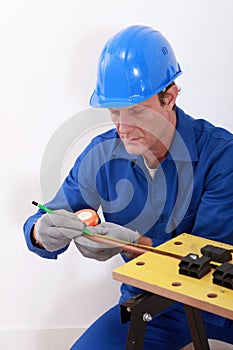 Plumber measuring copper pipe