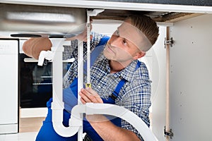 Plumber Measuring Sink Pipe