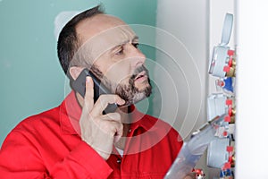 plumber on phone while installing pressure meter