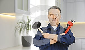 Plumber with pipe wrench and force cup in kitchen