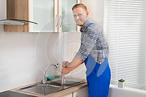 Plumber With Plunger In Kitchen