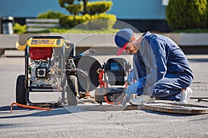 Plumber prepares to fix the problem in the sewer with portable camera for pipe inspection and other plumbing work