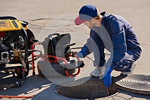 Plumber prepares to fix the problem in the sewer with portable camera for pipe inspection and other plumbing work