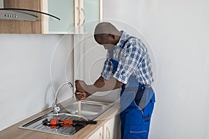 Plumber Pressing Plunger In Sink