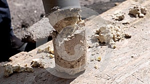 A plumber removes solid deposits from grease and debris.