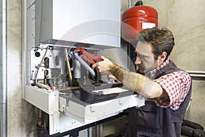 Plumber repairing a condensing boiler