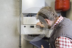 Plumber repairing a condensing boiler