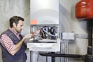 Plumber repairing a condensing boiler