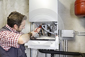 Plumber repairing a condensing boiler photo